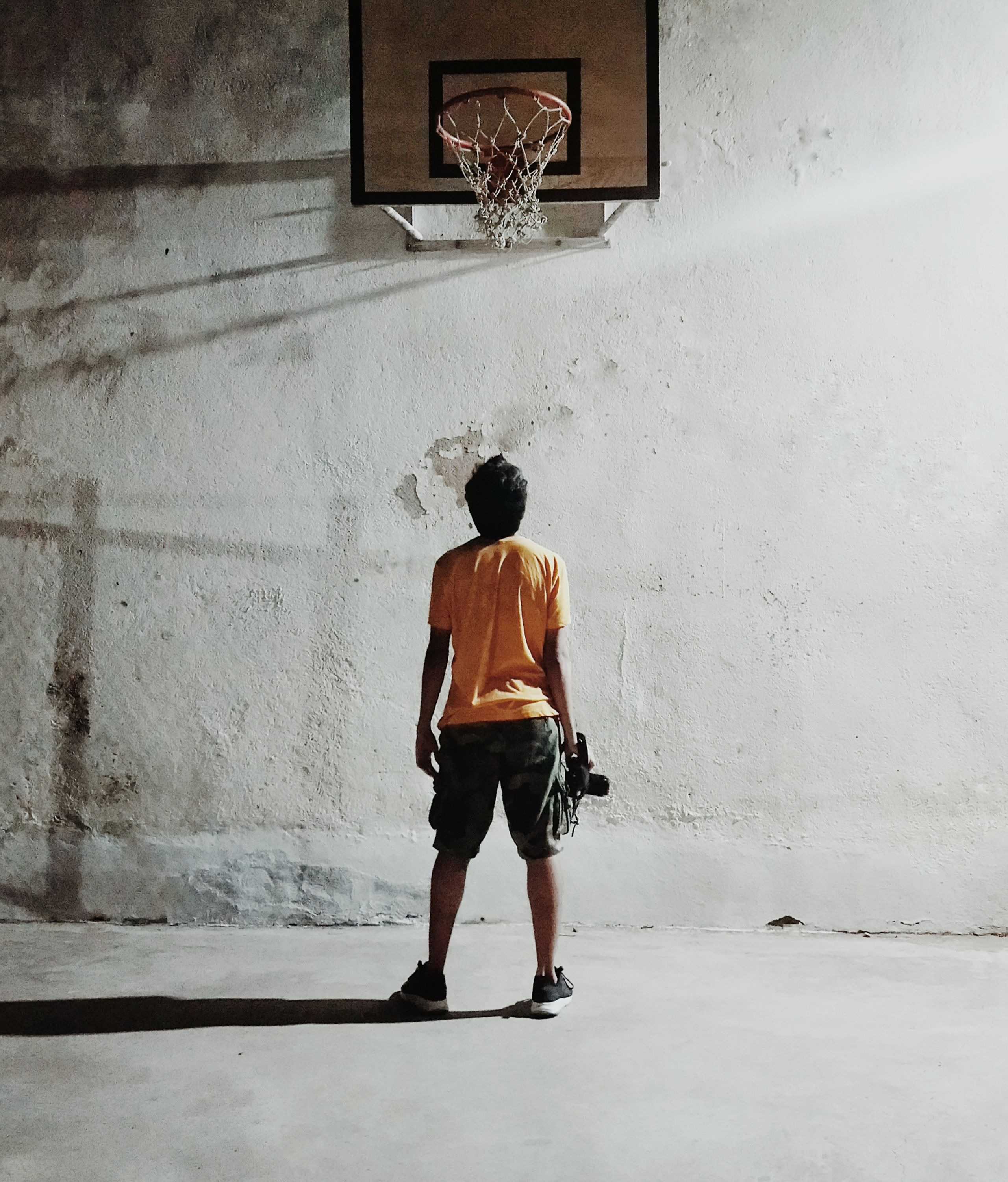 Photo Boy standing in front of a Basketball court